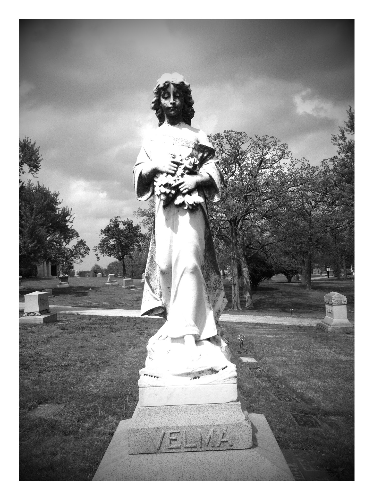 gravestone statue of girl holding flowers
