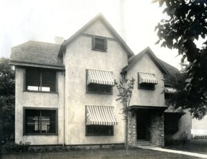 Historic exterior of an Austin Allen-designed house with striped awnings