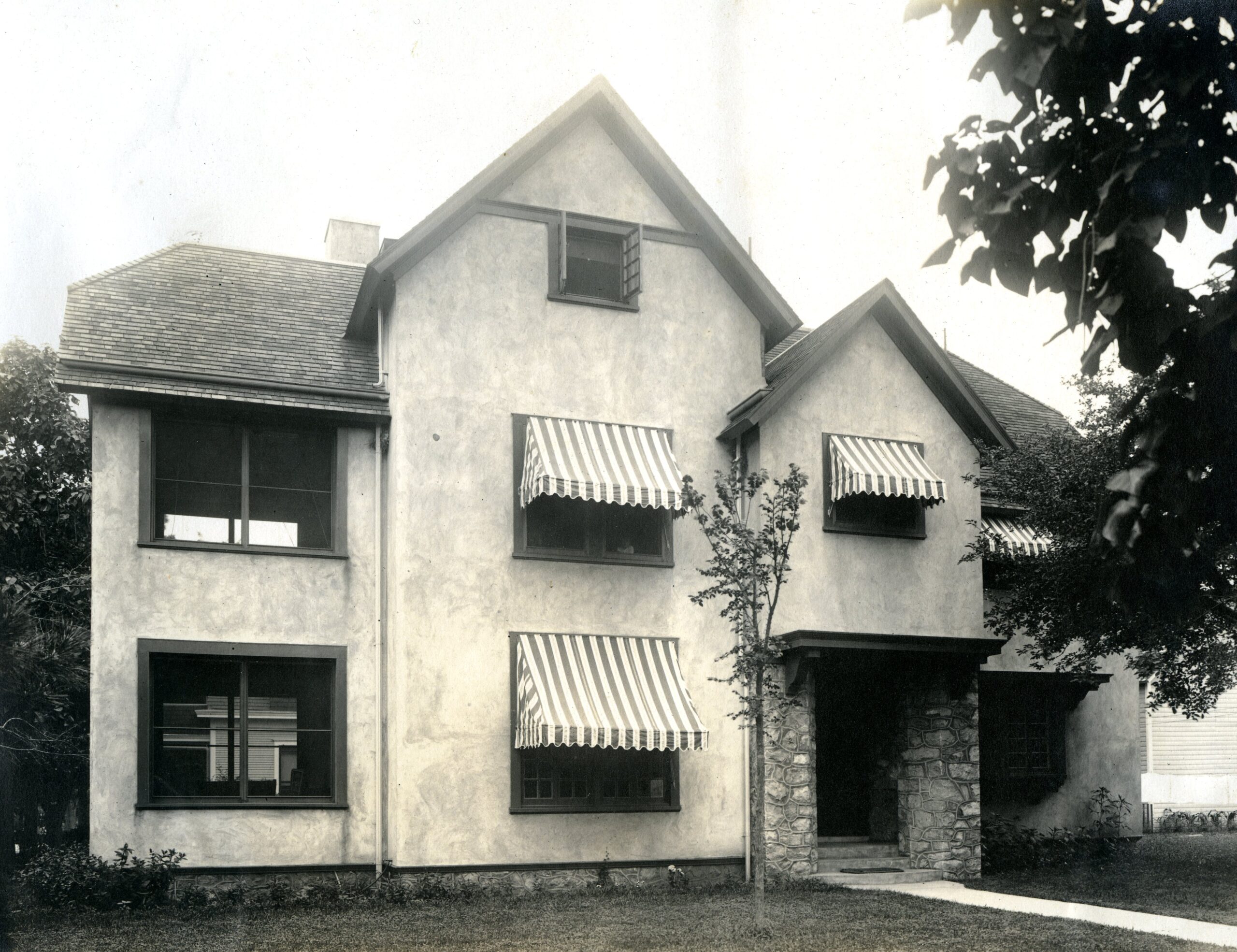 Historic exterior of an Austin Allen-designed house with striped awnings